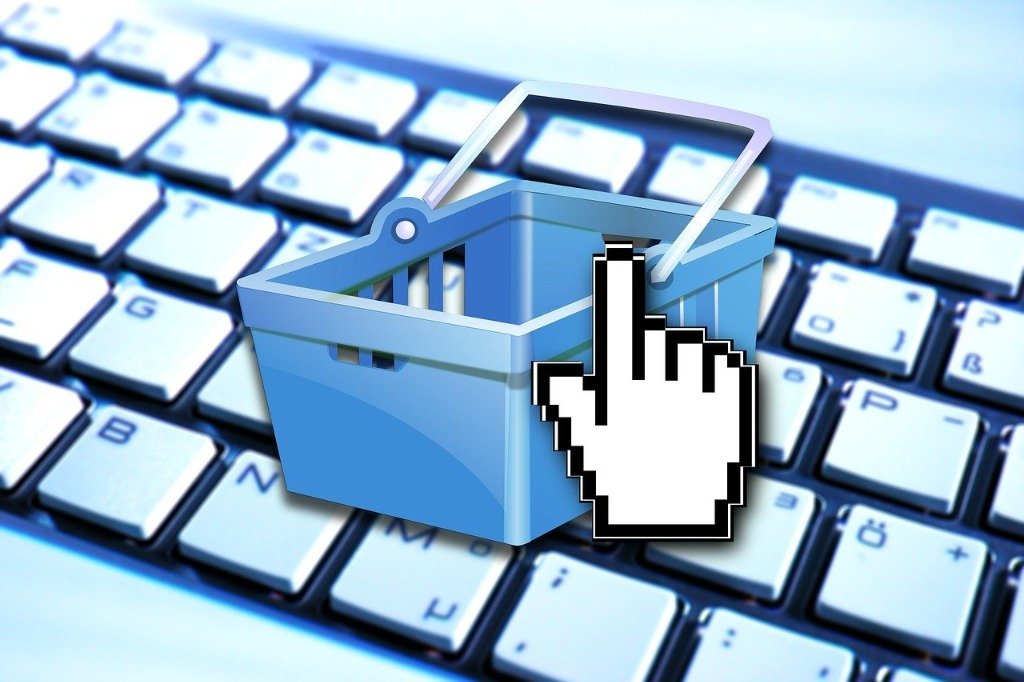 Stock illustration of a shopping-basket cursor icon hovering over a computer keyboard, representing online Shopify checkout